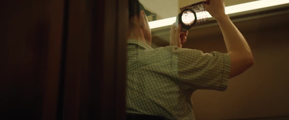 A man is examining something with a magnifying glass