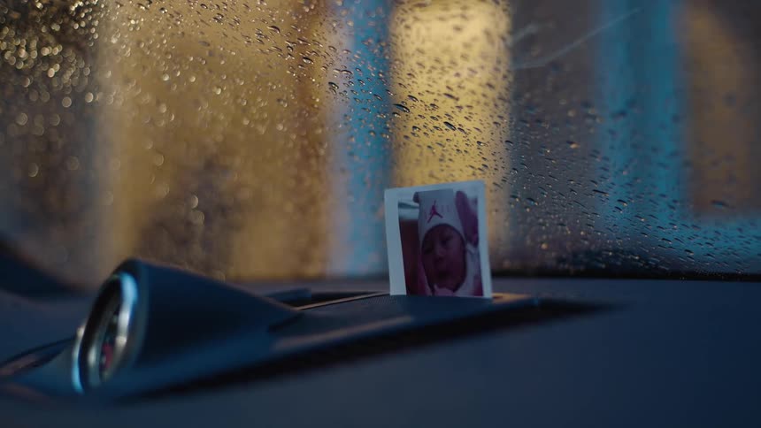 A picture sits on the dashboard of the car