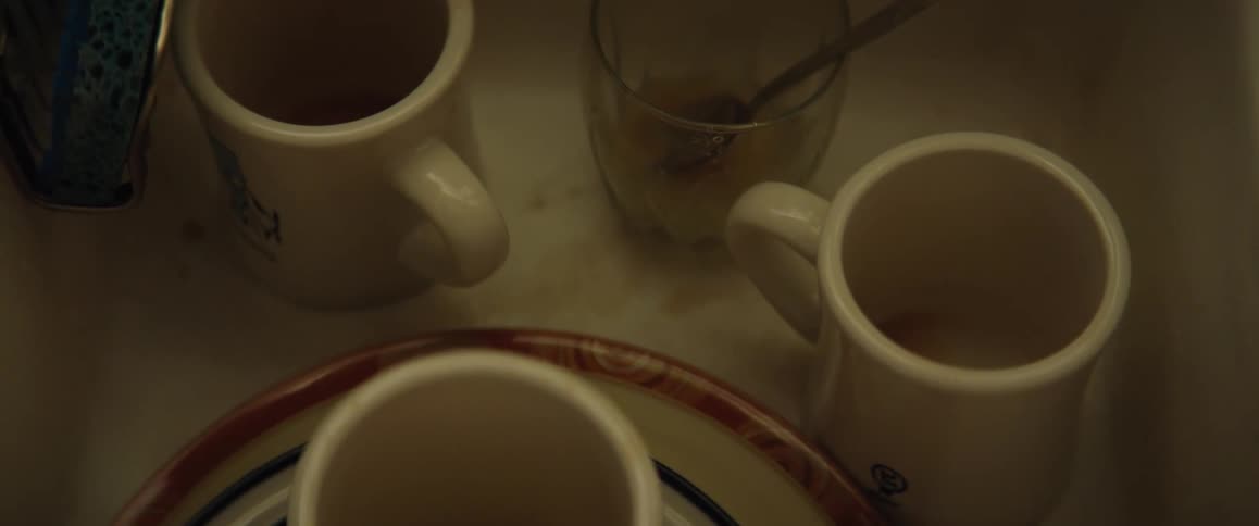 Cups and plates are left on a kitchen counter
