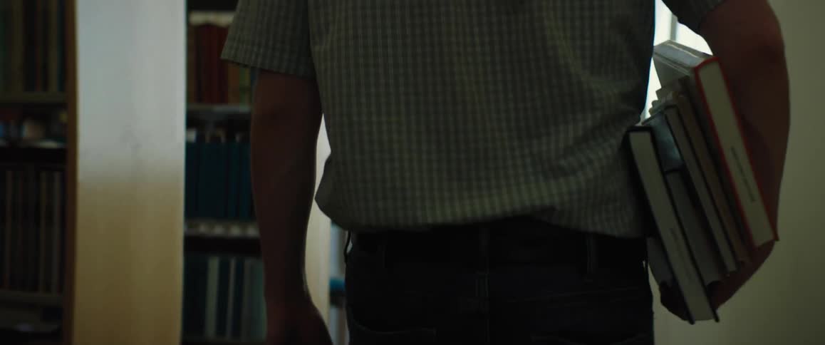 A man is carrying books in the library