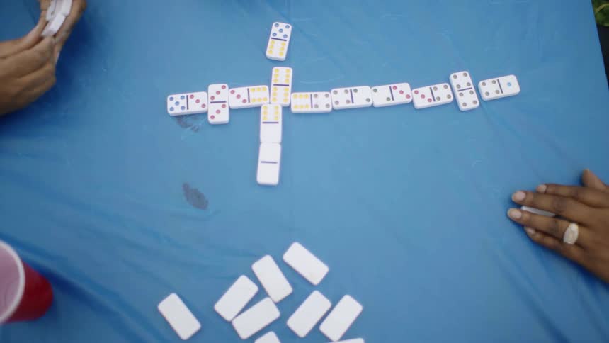 People are playing dominoes together