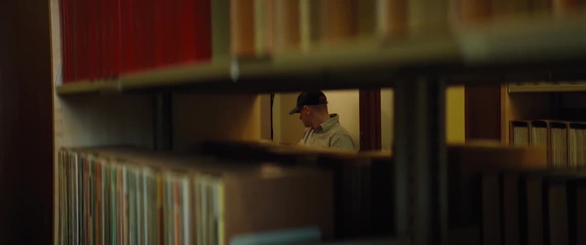A man goes through a stack of books at the library