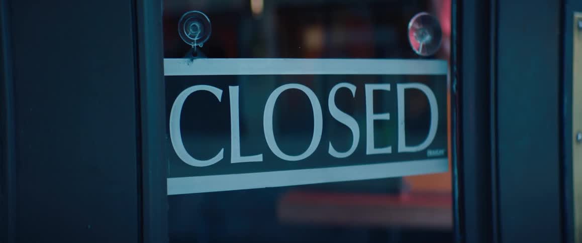 The store has a closed sign on the window