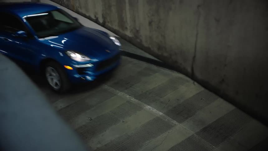 A car travels on a parking garage ramp