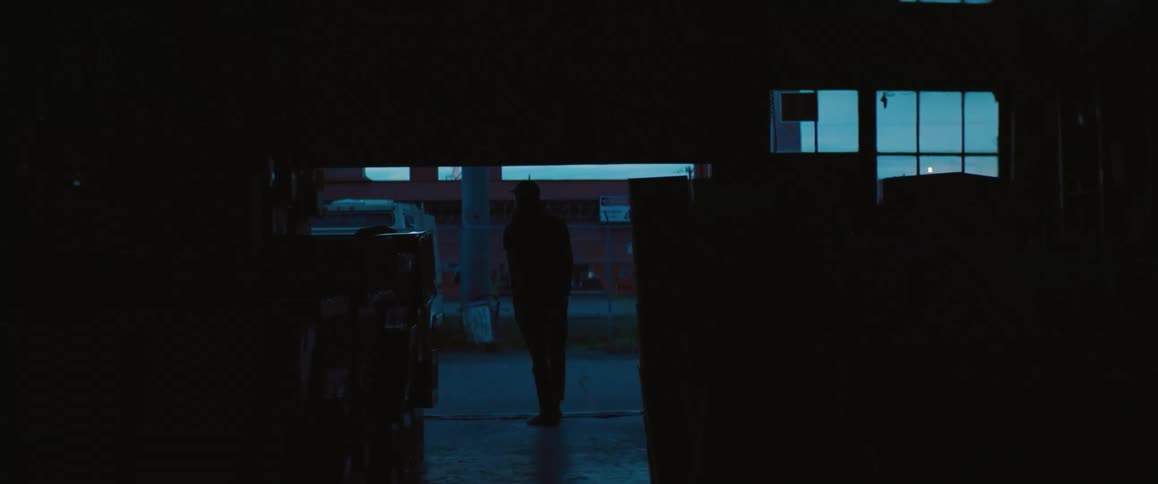 A man stands in silhouette as a bay door goes up