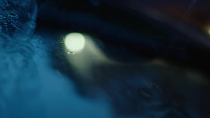 Rain is pouring on a windshield of a car