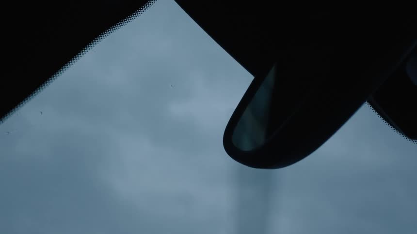 Wipers clear the rain drops off the car glass