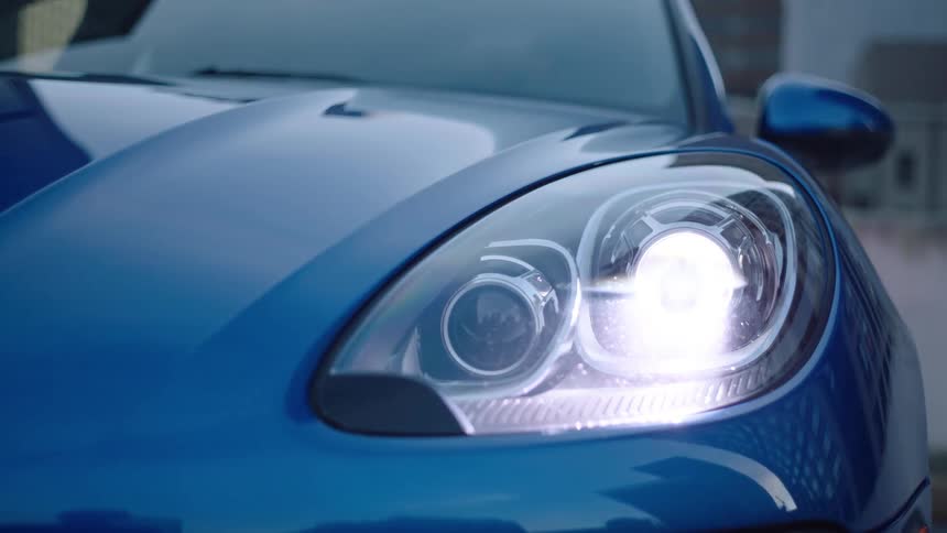 Blue sports car turns on headlights