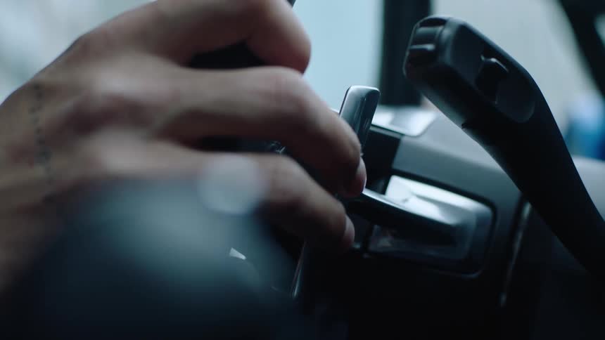A driver is holding a steering wheel and turning it
