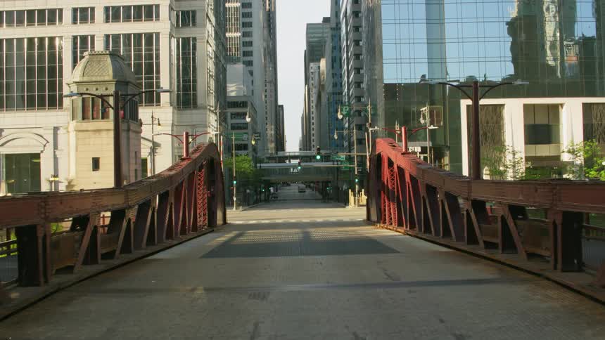 Bridge leading into an empty avenue through downtown chicago