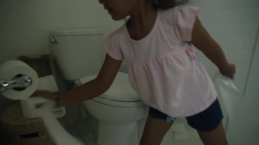 A child pulling out lots of toilet paper