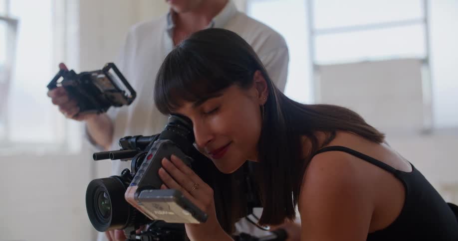 A man and woman are talking together and looking at cameras