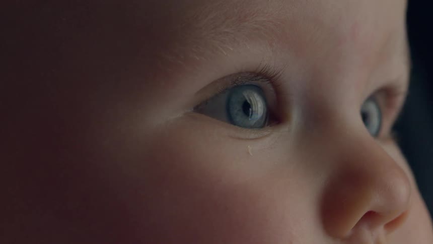 A baby is staring wide eyed at something