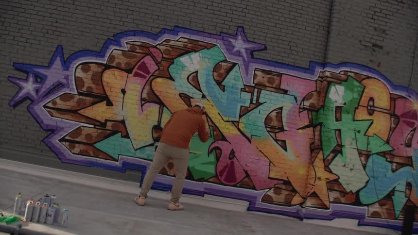 A man spray painting a wall