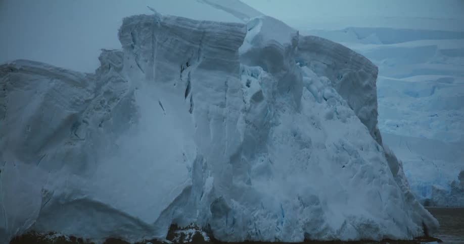 A large iceberg has broken off and floats near land