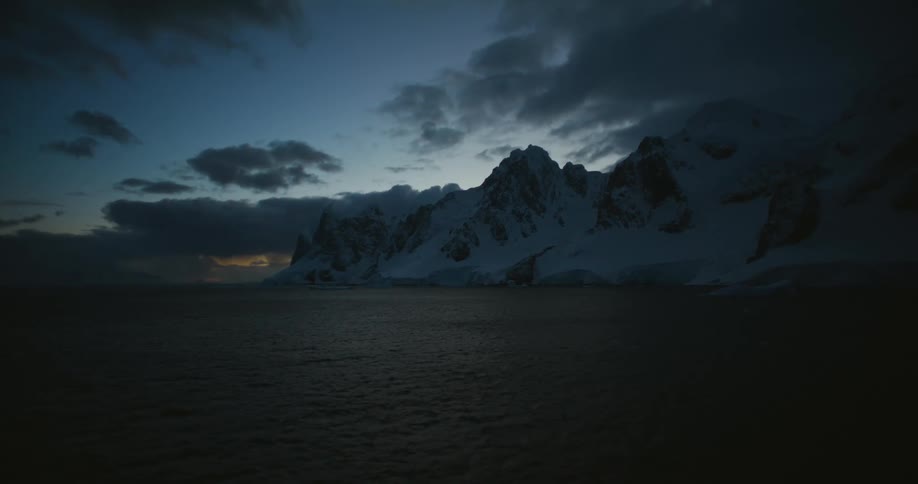 A view of snow on mountains near the ocean