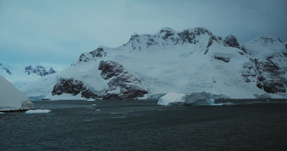 The mountain is covered with snow by the shore