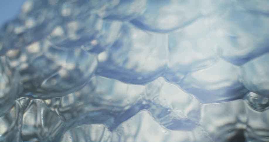 Sun shines through the faceted surface of a glass decor against a blue sky