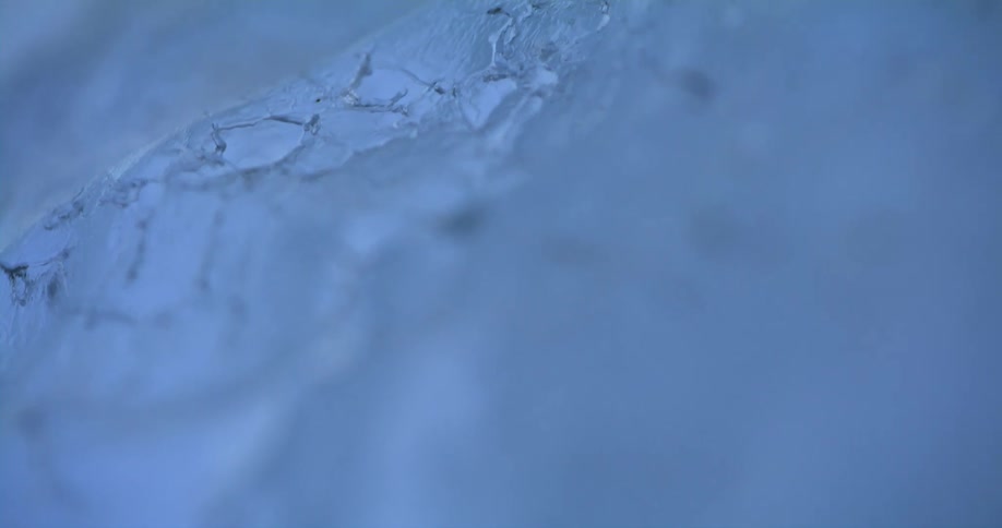 Light reflects on cracks in the snow covered ice