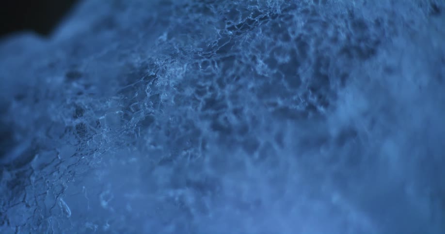 Cracked surface of an ice sculpture reflecting blue light