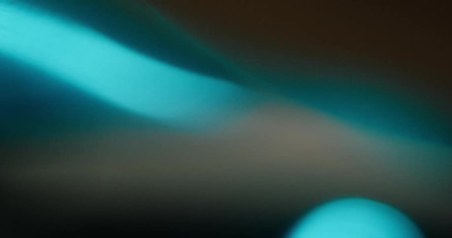 A light blue light moves across a hazy object in the darkness