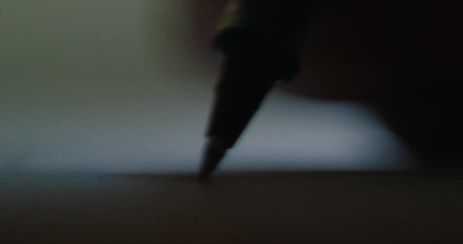 A person scribbles on paper with a marker