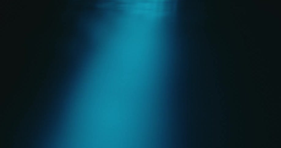 A blue light beam moves across black shadow