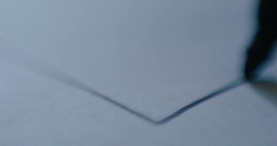 Close up of a felt marker drawing a line on paper