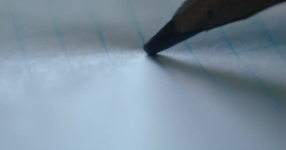 A pencil is moving across blue lines on paper