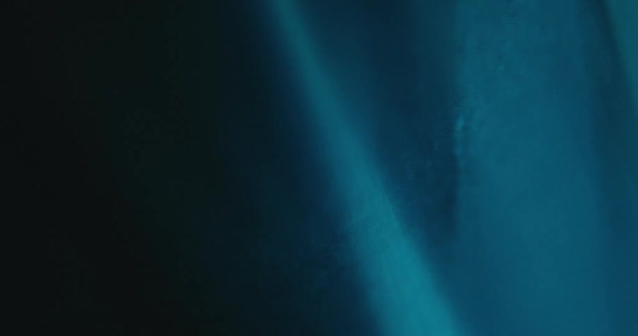 Electric blue beam of light passes over dark stone