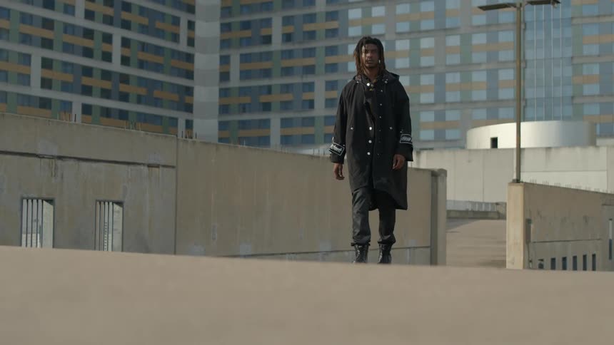 A man walks on the rooftop of a building downtown