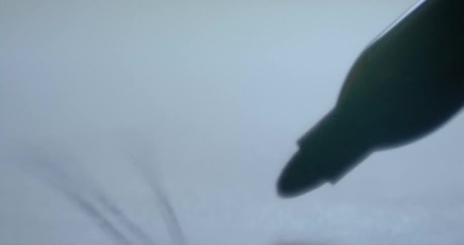 The tip of a felt tip pen draws lines and a box on paper
