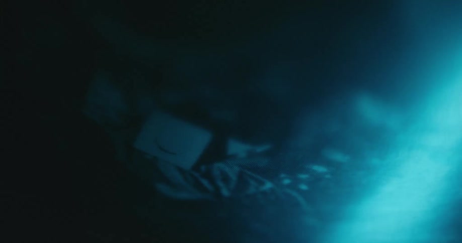 Abstract footage of a bright light moving across photo of debris lying in dirt