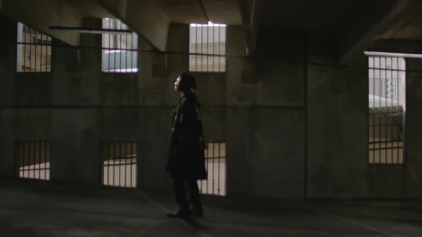 A man stands in a parking garage and looks around