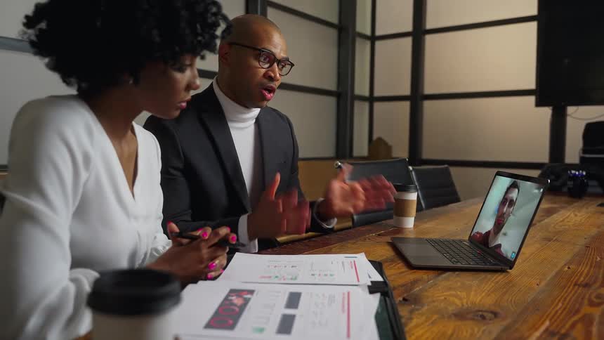 Colleagues chat over video call on a laptop