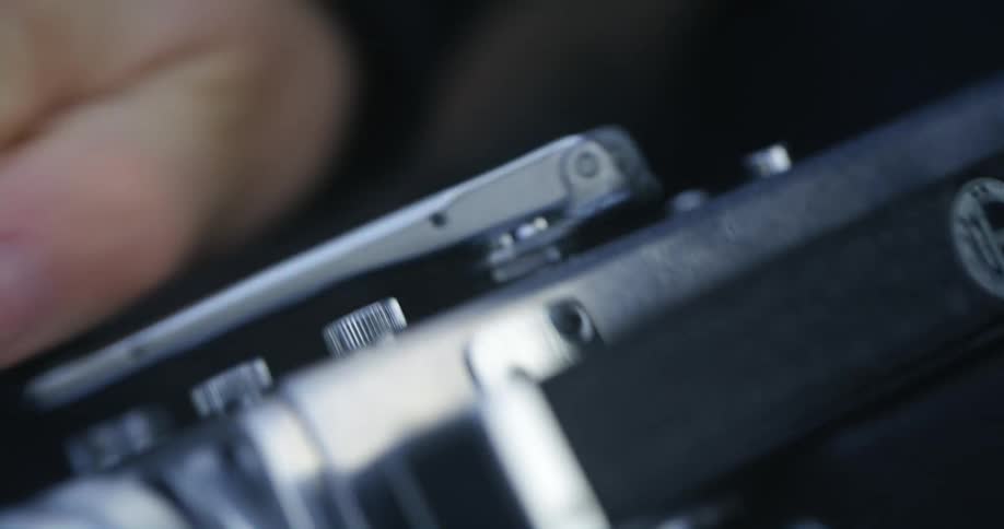 A hand turning the crank on a vintage camera