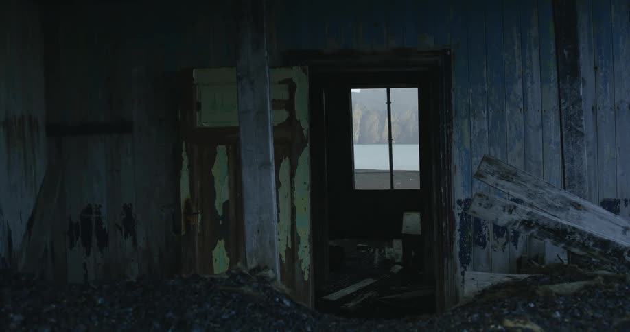 Rotting wood sits in a run down cabin