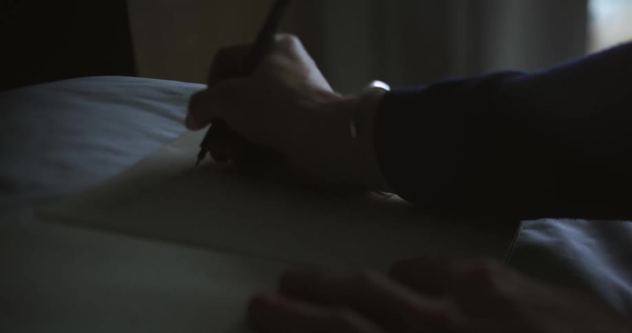 A person is writing in the notebook