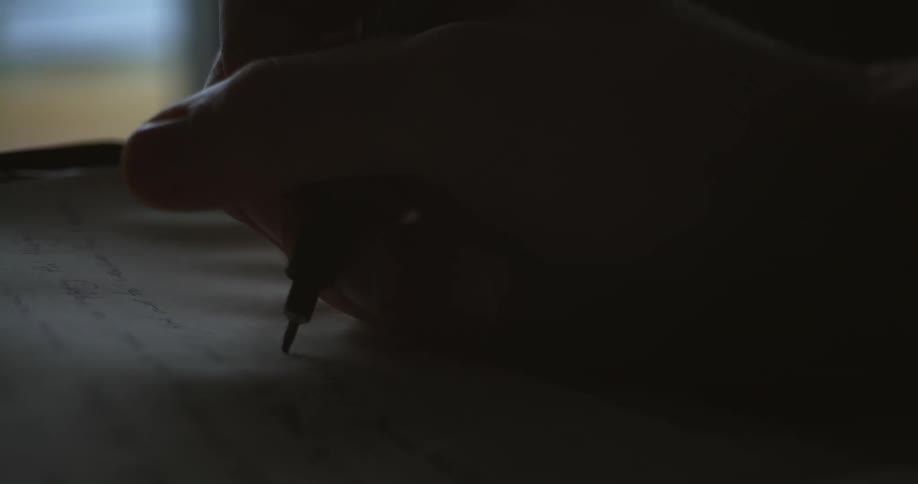 A person uses a pen to write on a sheet of paper