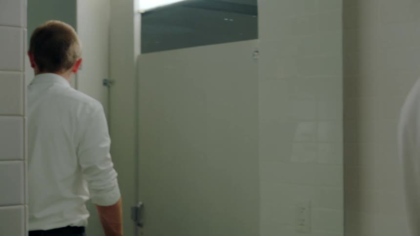 A man walking around in a bathroom