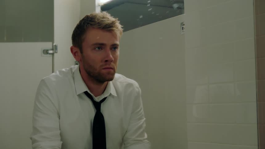 A man looks in the bathroom mirror worried