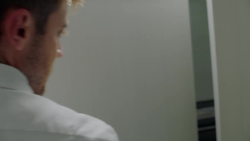 A man in a room closing a door