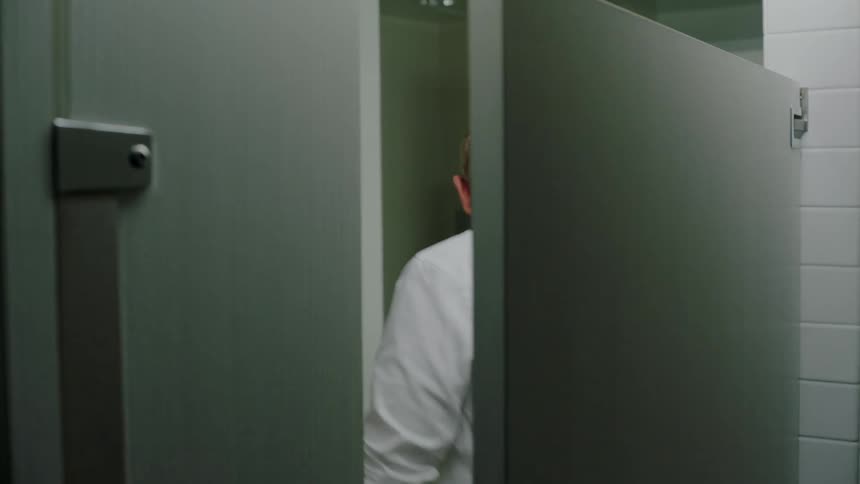 A man opens the bathroom stall door