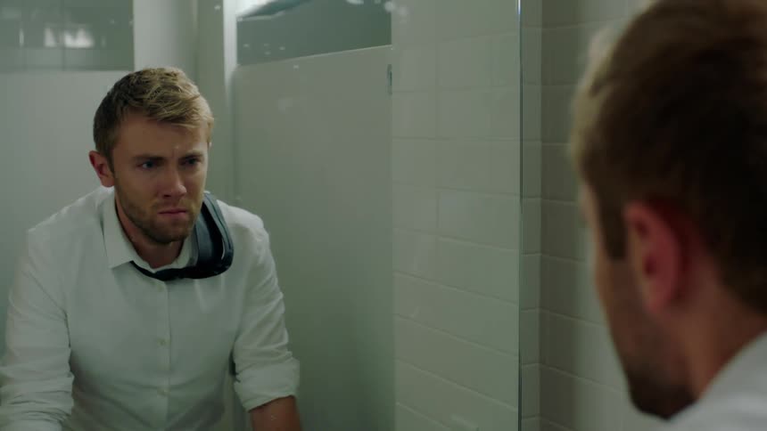 A man looks nervous in the mirror