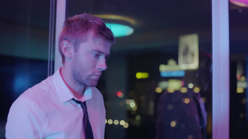 A man is walking by an office window at night