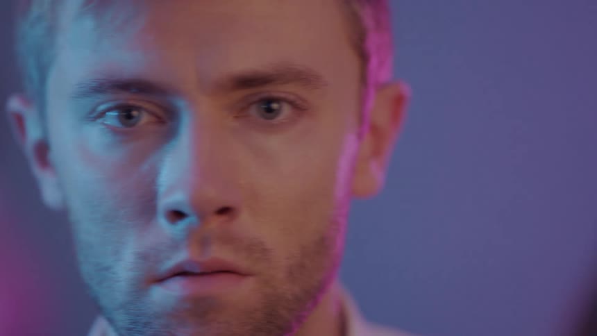 A portrait of a man standing in a room