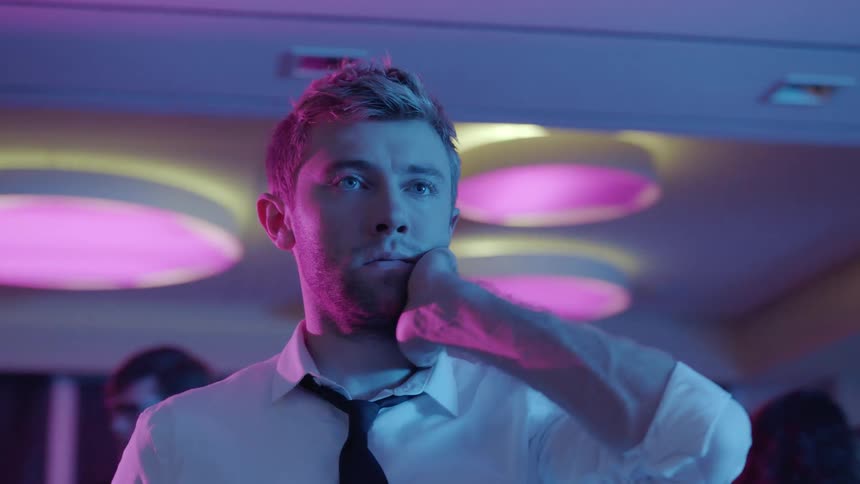 A man is standing in a room with people in it