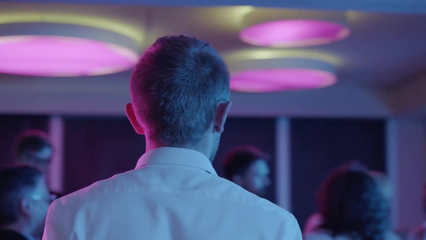 A man is looking around at people at a party