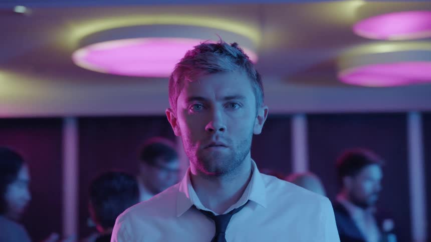 A man is standing in the middle of a party