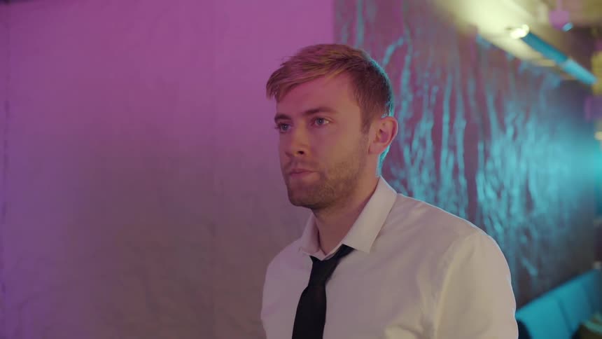 A man is walking by a building outdoors at night